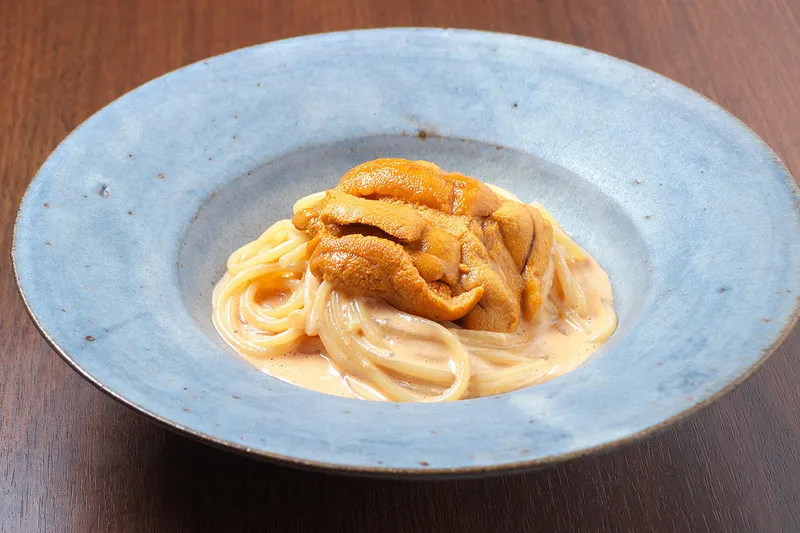 青い器に盛り付けた雲丹のトマトクリームソースパスタ